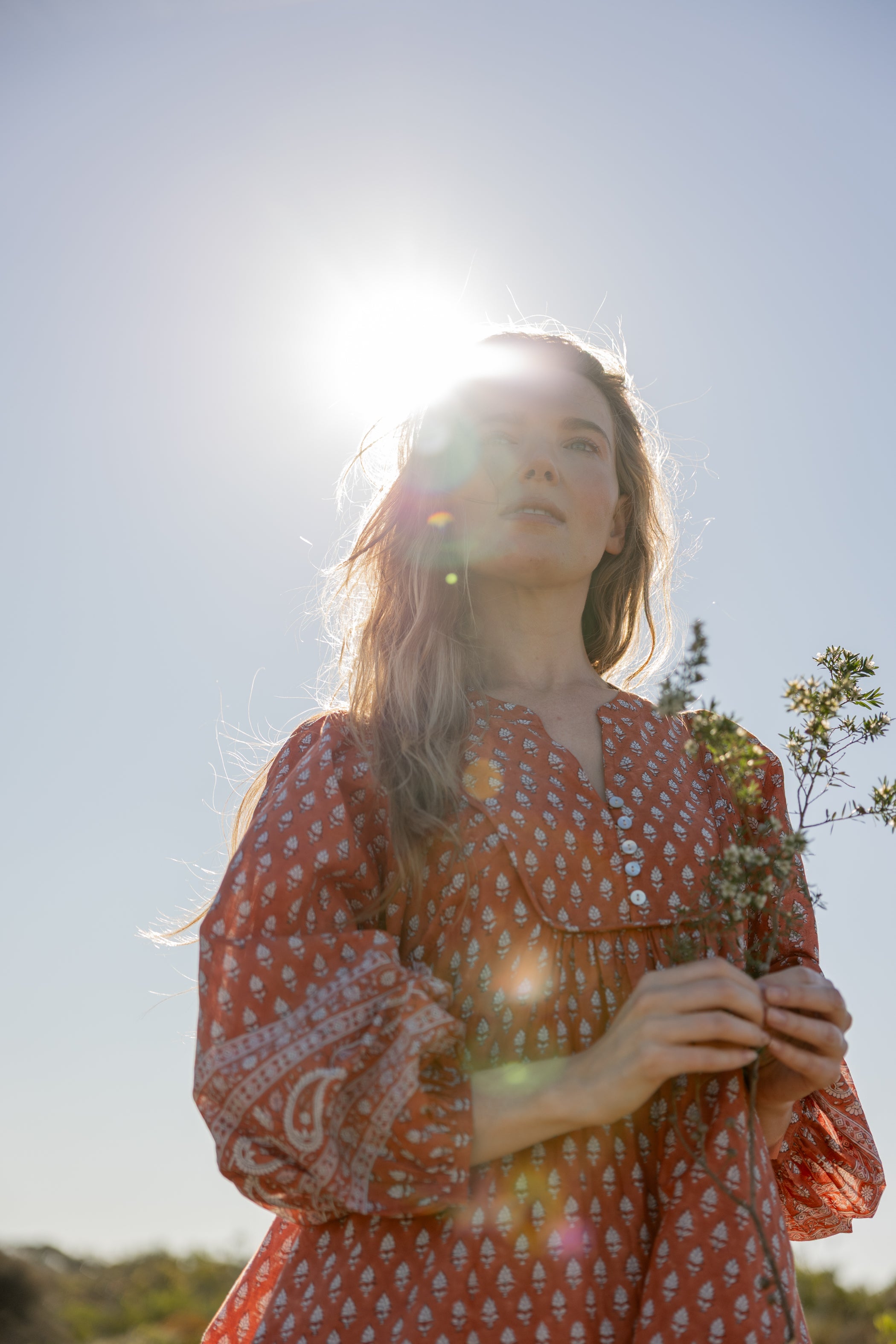 Made by Mortals women’s Desert Bloom Midi Dress in rust with billowy sleeves, hand block printed cotton bohemian dress by artisans in India.