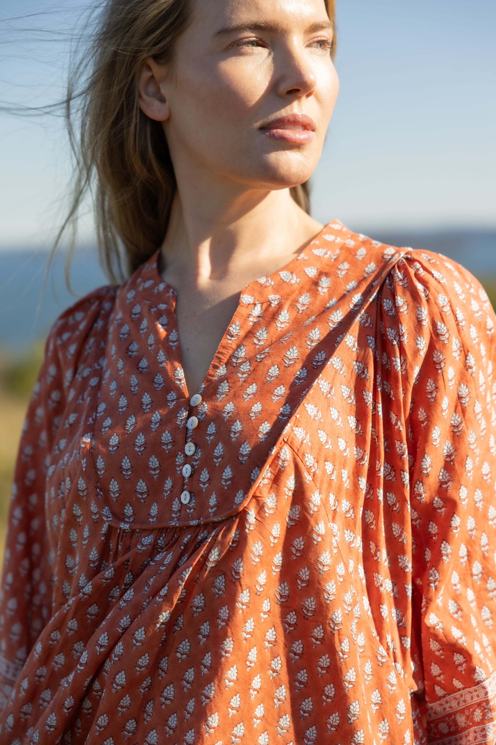 Made by Mortals women’s Desert Bloom Midi Dress in rust with billowy sleeves, hand block printed cotton bohemian dress by artisans in India.