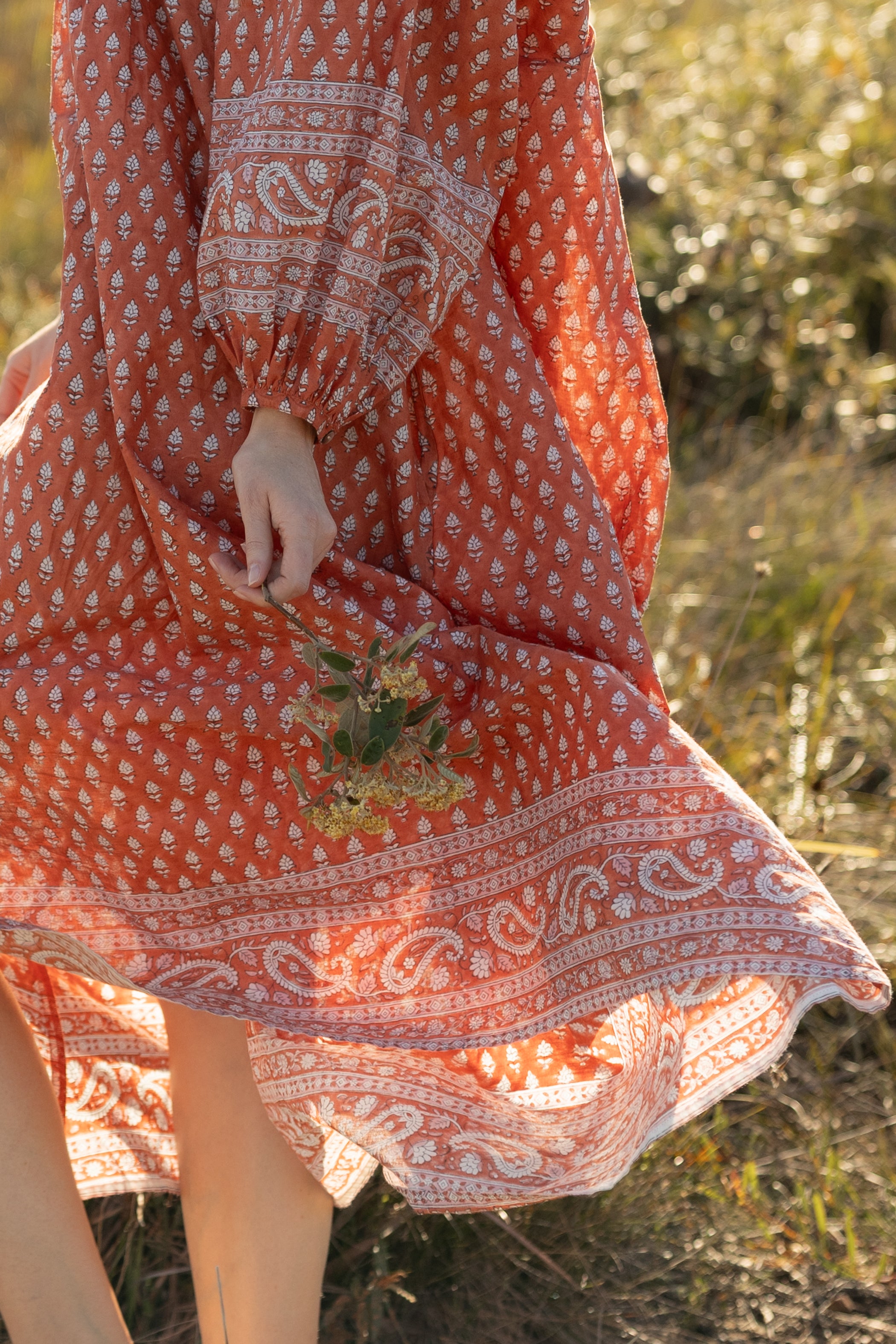 Made by Mortals women’s Desert Bloom Midi Dress in rust with billowy sleeves, hand block printed cotton bohemian dress by artisans in India.