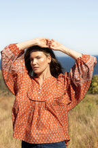 Made by Mortals women’s Desert Bloom Blouse with billowy sleeves, hand block printed bohemian cotton blouse in rust.