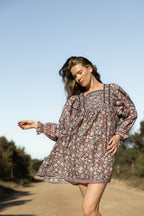 Made by Mortals women’s Jardin de Rose Mini Dress with billowy sleeves, hand block printed cotton bohemian dress in black with white, blue and pink floral pattern.