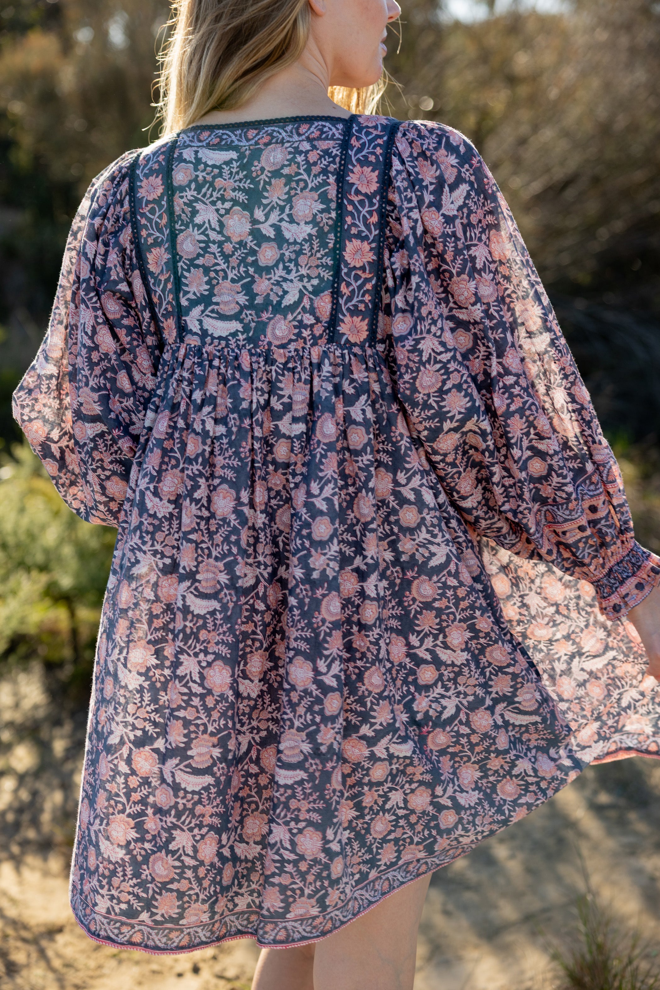 Made by Mortals women’s Jardin de Rose Mini Dress with billowy sleeves, hand block printed cotton bohemian dress in black with white, blue and pink floral pattern.