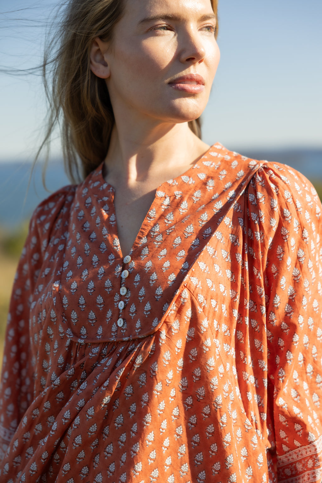 Made by Mortals women’s Desert Bloom Midi Dress in rust with billowy sleeves, hand block printed cotton bohemian dress by artisans in India.