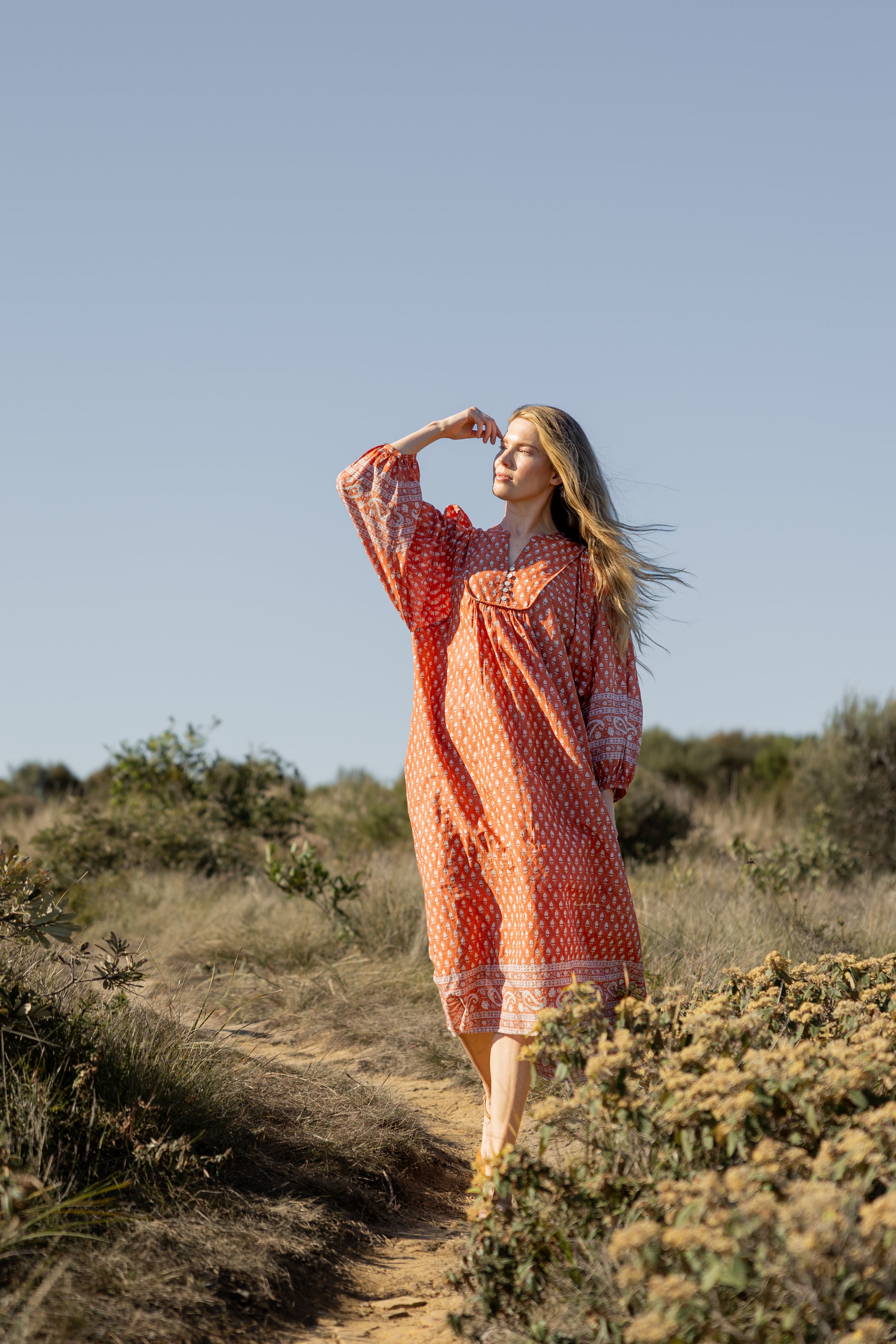 Made by Mortals women’s Desert Bloom Midi Dress in rust with billowy sleeves, hand block printed cotton bohemian dress by artisans in India.