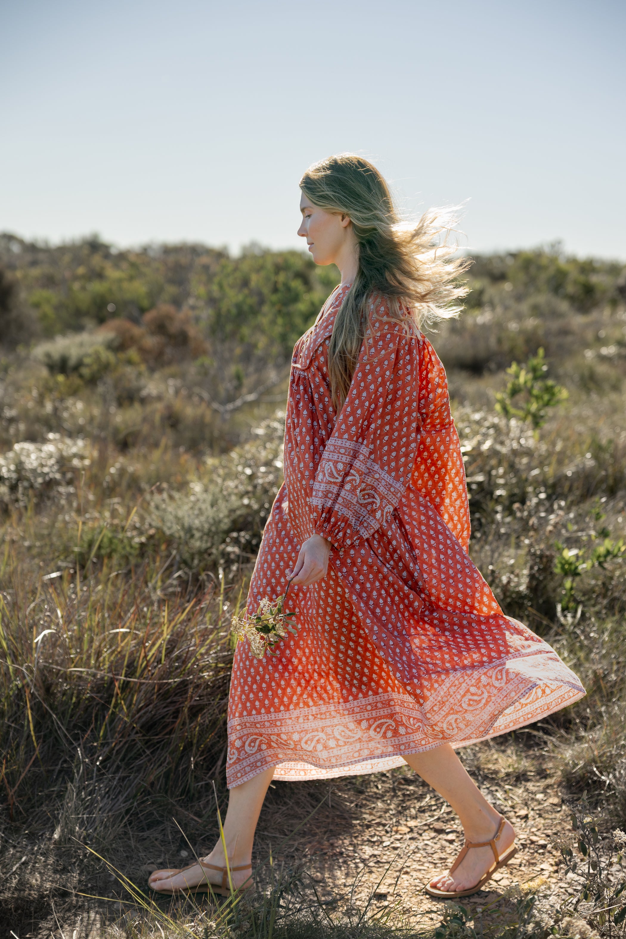 Made by Mortals women’s Desert Bloom Midi Dress in rust with billowy sleeves, hand block printed cotton bohemian dress by artisans in India.