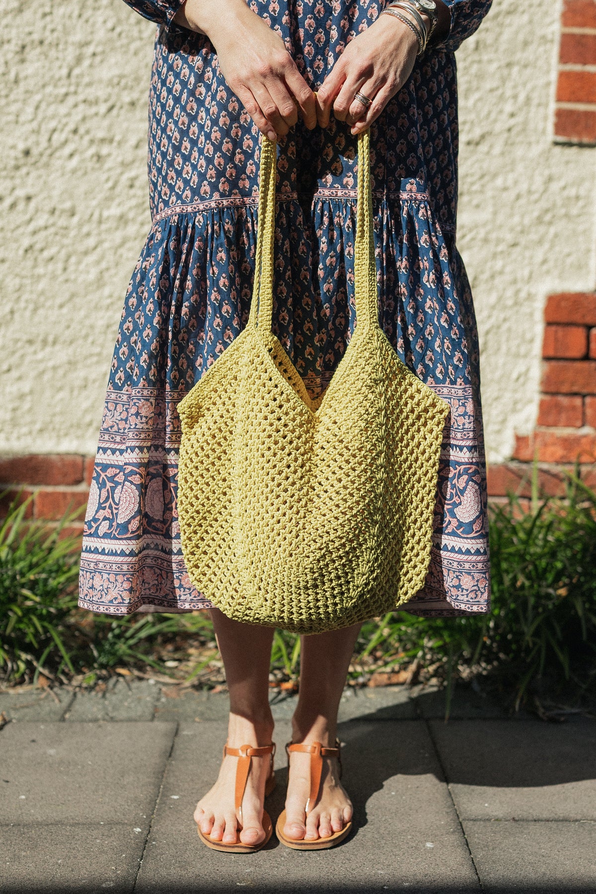 Sorrento Crochet Tote, a lightweight cotton crochet bag in acid worn with a hand block print cotton dress.