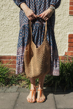 Sorrento Crochet Tote, a lightweight cotton crochet bag in caramel worn with a hand block print cotton dress.