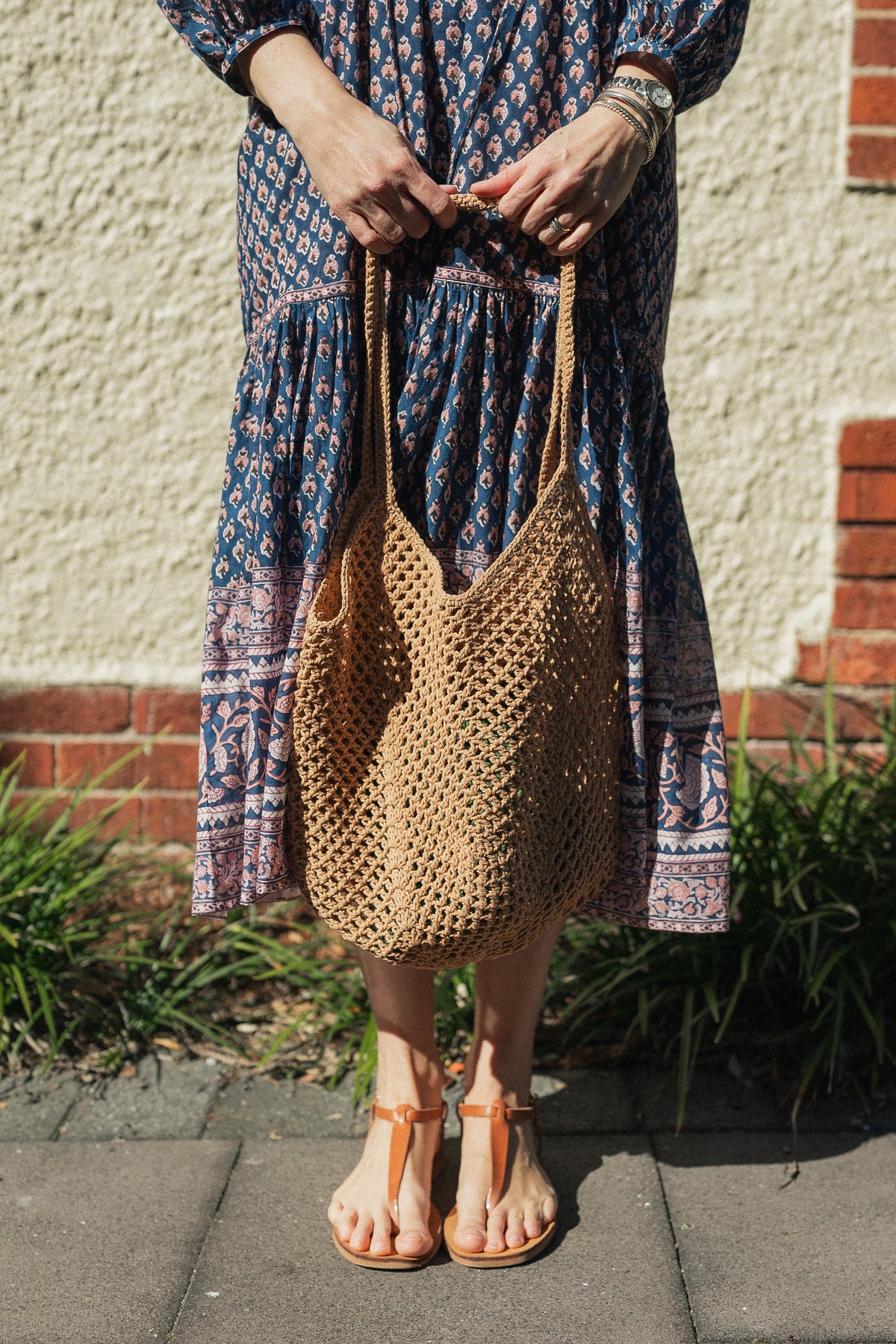 Sorrento Crochet Tote, a lightweight cotton crochet bag in caramel worn with a hand block print cotton dress.