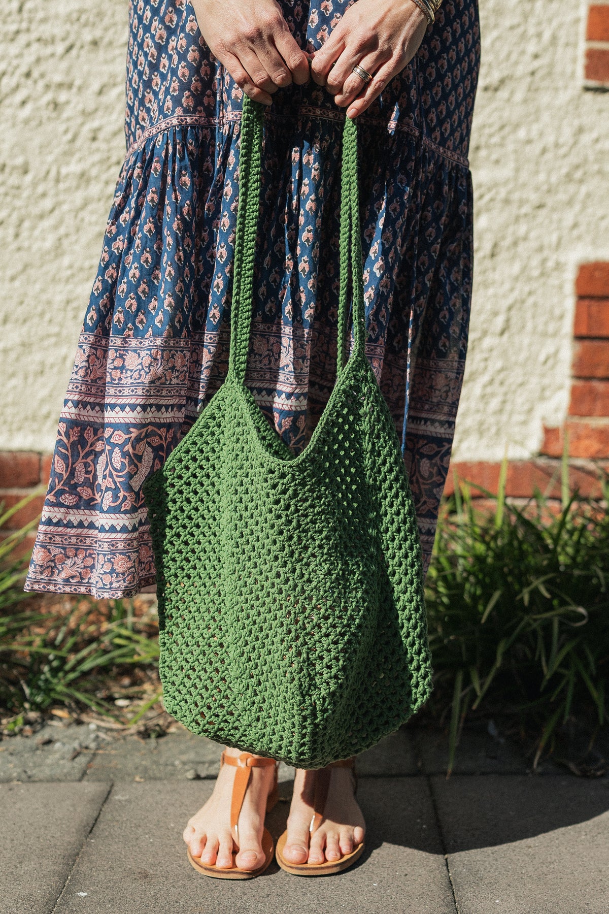Sorrento Crochet Tote, a lightweight cotton crochet bag in green worn with hand block print cotton dress.