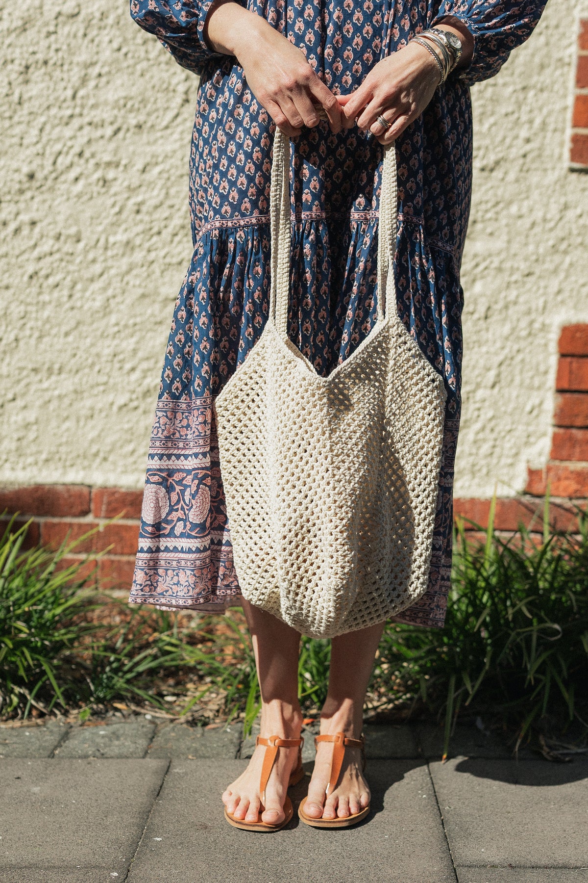Sorrento Crochet Tote, a lightweight cotton crochet bag in off white worn with a hand block print cotton dress.