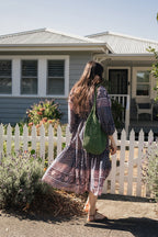 Woman in front white picket fence wearing the Lisette Midi Dress, a navy and soft nude hand block print cotton midi dress.