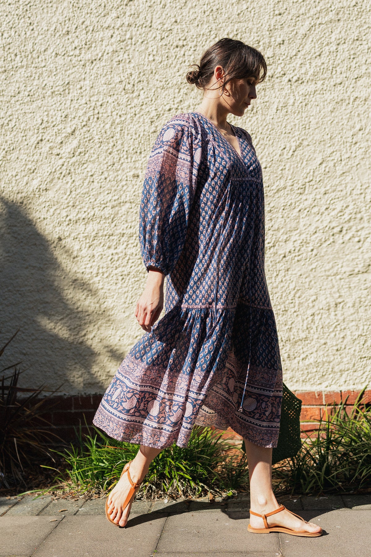 Woman wearing the Lisette Midi Dress, a navy and soft nude hand block print cotton midi dress. 